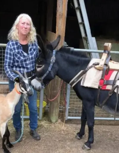 Florence avec un âne bâté et une chèvre "Cou clair du Berry" sur le site de l'Âne Archie du Berry à Bazaiges dans l'Indre.